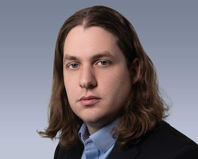 The same man with a neutral, slightly serious expression.
